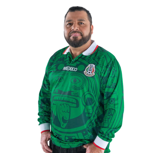 A man wearing the green long sleeve Mexico 1998 soccer jersey with an Aztec calendar print as seen in image_0.jpg.